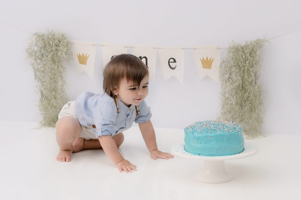 North Vancouver Photography Studio - Cake Smash - First Birthday Boy crawling towards a blue cake with sprinkles