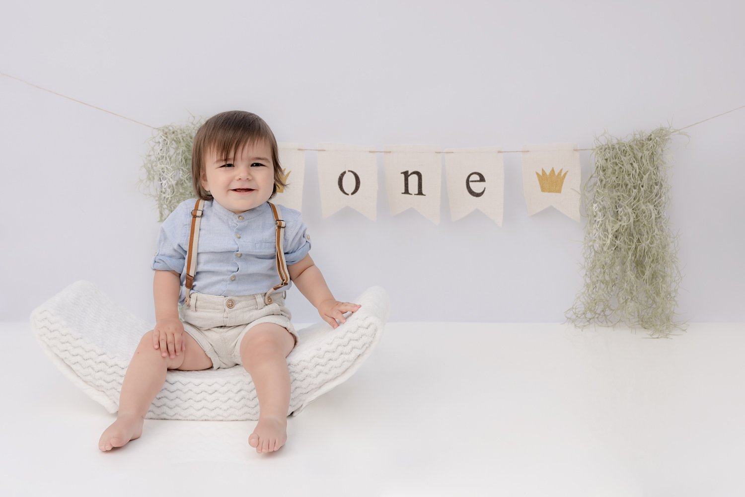 North Vancouver Photography Studio - Cake Smash - First Birthday Portrait picture of a 1 year old sitting in front of a banner with the word one