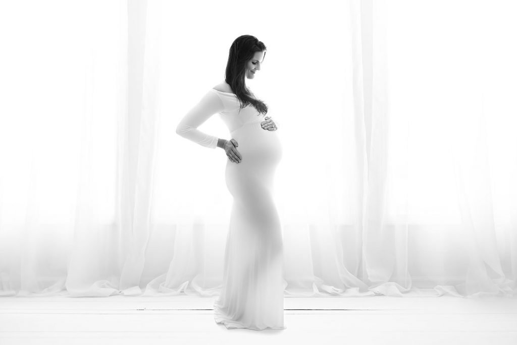 For First-Time Moms Over 40: Why Your Pregnancy Deserves to Be Celebrated 4 Pregnant woman in front of white curtain