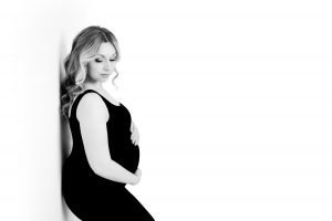 Maternity Photography Vancouver - Pregnant woman leaning on a wall looking down