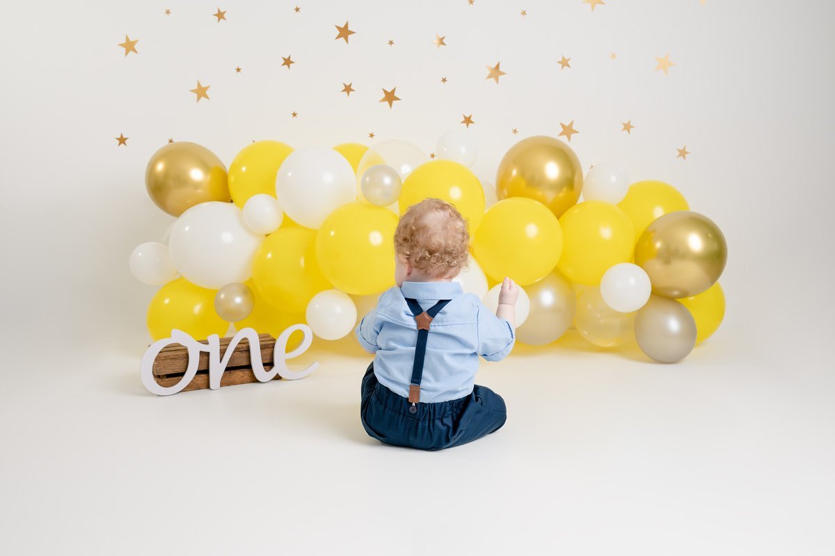 Baby Photographer North Vancouver - baby looking at yellow balloons