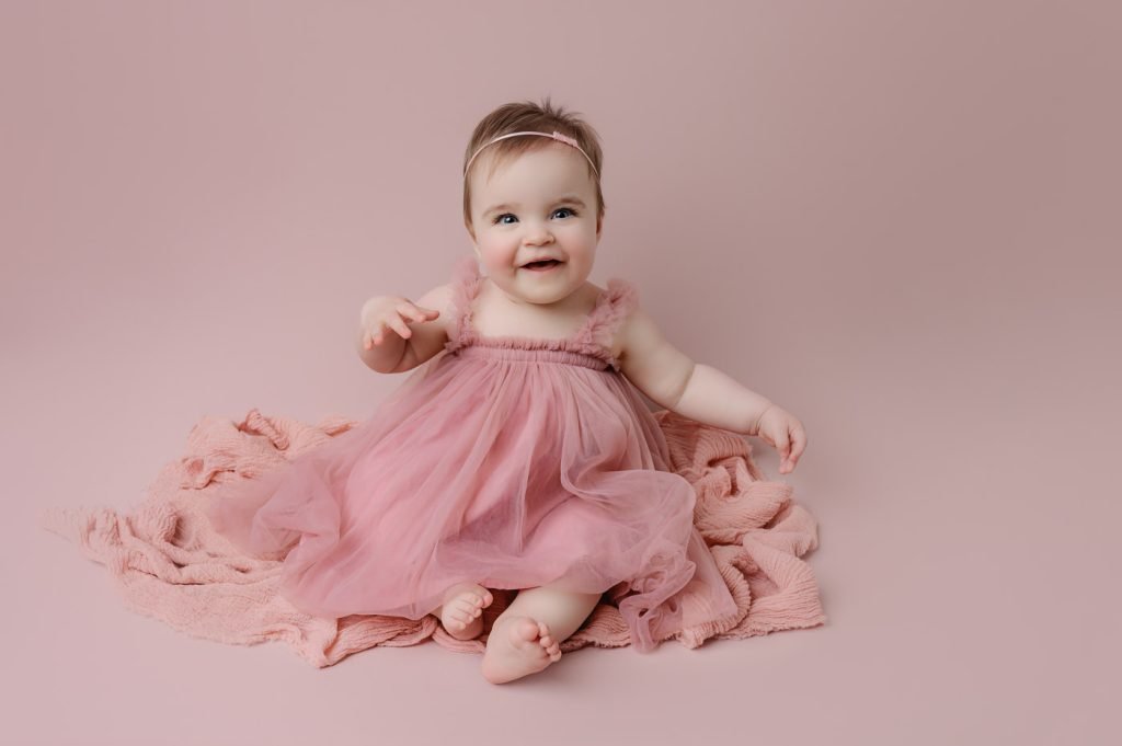 Baby Photography Vancouver - Baby Girl smiling on pink backdrop