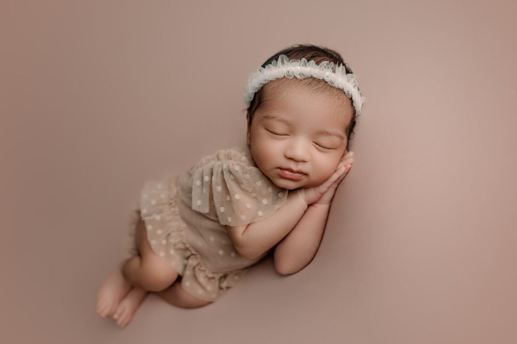 Newborn Photography Vancouver - baby girl sleeping on her hands on pink backdrop
